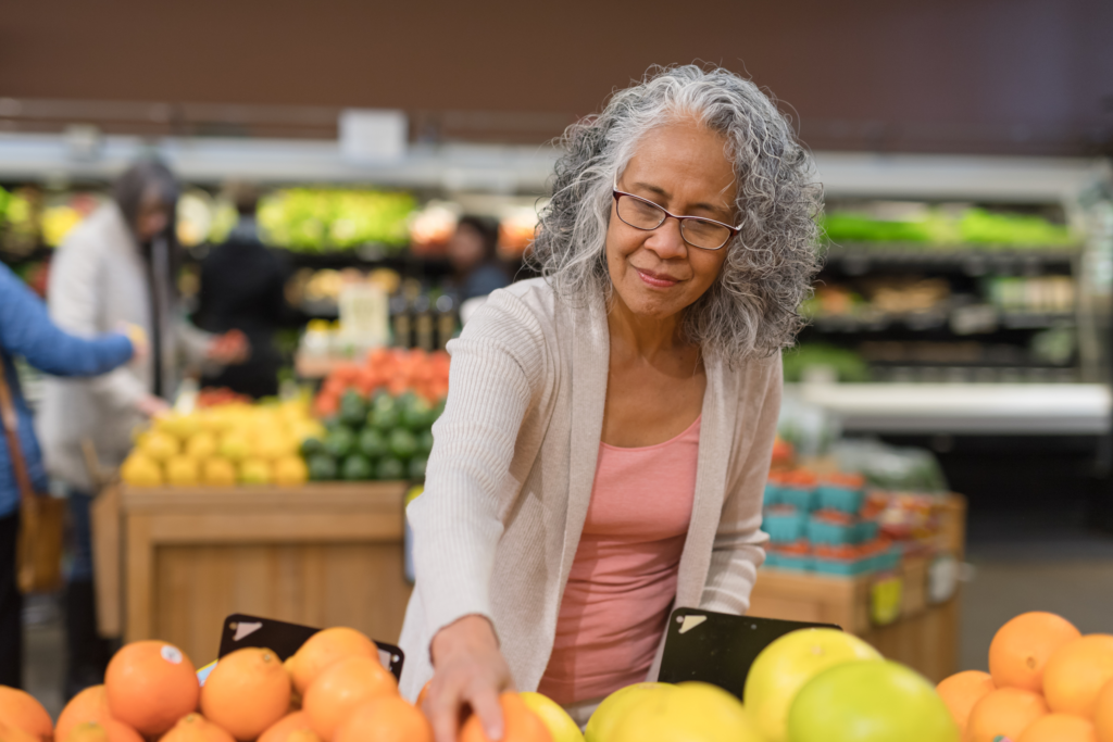 A woman happily shopping at a grocery store