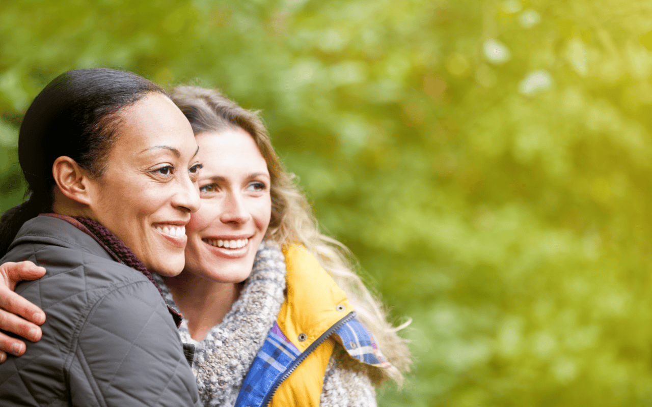 Two women outside, hugging and smiling