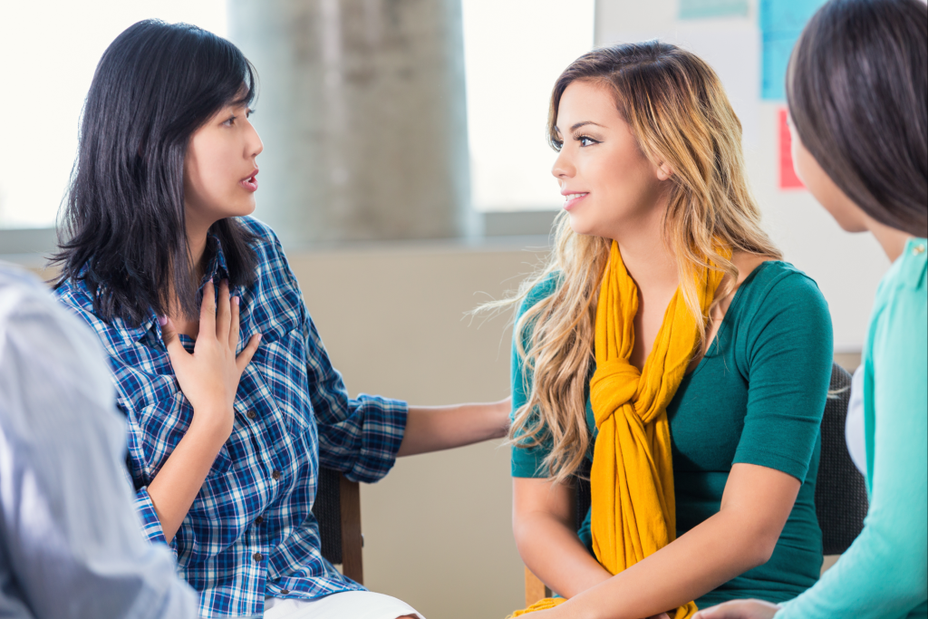 Two caregivers talking in a supportive environment.